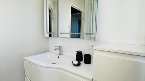 a white bathroom with a sink and a mirror at Le Balcon Bohème - Troyes à pied et Parking in Saint-André-les-Vergers