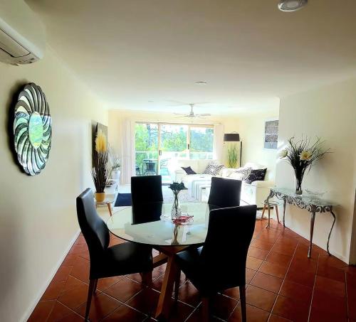 a dining room and living room with a table and chairs at Beach-Pool-Tennis-Ocean Views-All at Your Door in Surf Beach