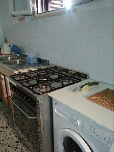 a kitchen with a stove and a washing machine at B&B 'Tra i due Parchi'' in Avezzano