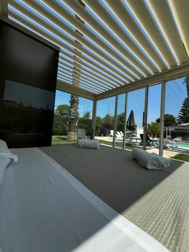 a bedroom with a large bed with a flat screen tv at Villa Dalesco in Leverano