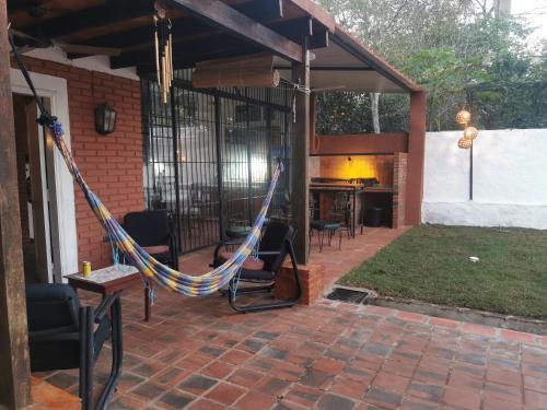 a patio with a hammock and a fireplace at Ysapy Hostel in Piribebuy