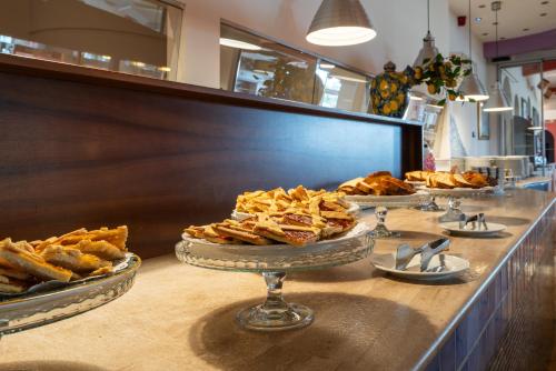 a buffet with several plates of food on a counter at Hotel Antares Sport Beauty & Wellness in Villafranca di Verona
