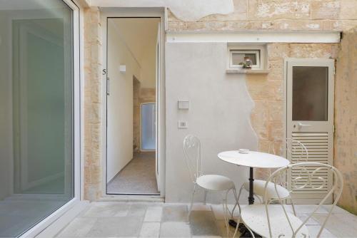 a room with a table and chairs next to a door at Liberty Barocco in Lecce