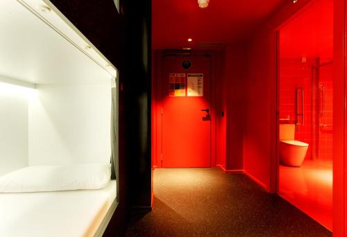 a red hallway with a bed and a red door at AMISTAT City Hostel Barcelona in Barcelona