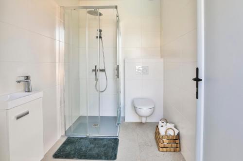 a bathroom with a glass shower with a toilet at Villa d'exception avec piscine, proche de la mer in Les Sables-dʼOlonne