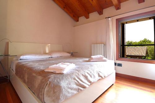 a bedroom with a large bed with a window at Silea Apartments, Pool, Garden, Treviso in Silea