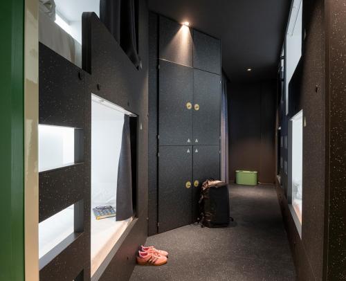 a hallway with black lockers and a suitcase in a room at AMISTAT City Hostel Barcelona in Barcelona
