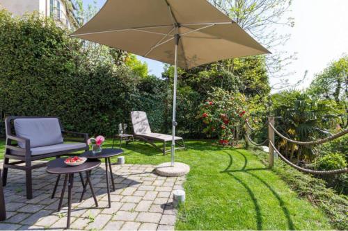 a patio with two chairs and an umbrella at La Villa vacation home Lake Como in Como