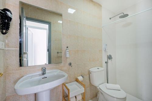 Un baño con lavabo, inodoro y espejo. en Ura Roslara, en Puerto Rico de Gran Canaria