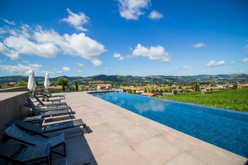 a villa with a swimming pool and lounge chairs at Cantina Semonte Wine Resort in Gubbio