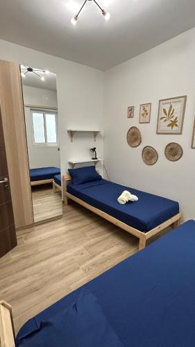 a bedroom with a blue bed and a mirror at Anton Court in Xlendi
