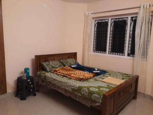 a bed in a room with a window and a bed sidx sidx sidx at NectorNest in Kodaikānāl