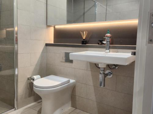 a bathroom with a white sink and a toilet at Skyline Comfort - Sydney Olympic Park in Sydney