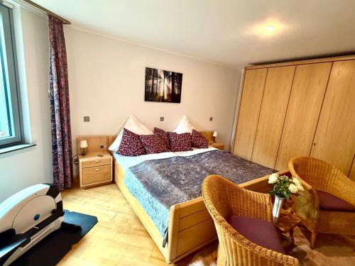 a bedroom with a bed and two chairs at Traumferienwohnung zwischen Köln und Düsseldorf in Leichlingen