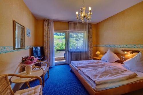 a hotel room with two beds and a window at Hotel - Garni - Wolfshof in Traben-Trarbach