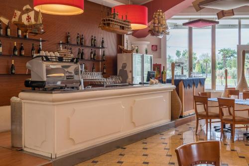 a bar in a restaurant with a counter and chairs at Hotel Antares Sport Beauty & Wellness in Villafranca di Verona
