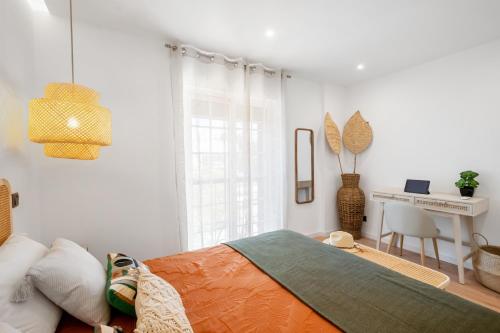 a white bedroom with a bed and a desk at Mae Joana pool&beach Faro villa in FAO