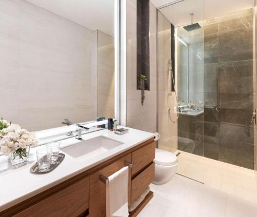 une salle de bain avec un lavabo, des toilettes et une douche dans l'établissement Hotel Tulip Near Delhi Airport, à Jāmb