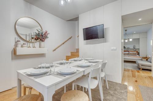 a white dining room with a white table and chairs at OPORTO GUEST Downtown Escape in Porto