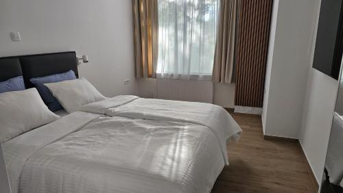 a bedroom with a large white bed and a window at Memento Ljubljana apartment 2-4 in Ljubljana