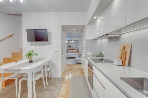 a white kitchen with a table and a dining room at OPORTO GUEST Downtown Escape in Porto