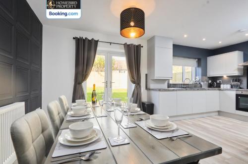 a dining room with a table and chairs and a kitchen at Spacious 4BDR House By Homebird Property Management Short Lets & Serviced Accommodation Leeds With Private Parking & Garden in Leeds