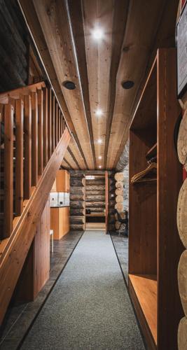 a hallway in a wooden barn with wooden walls and stairs at Talvihovi 5 in Ruka