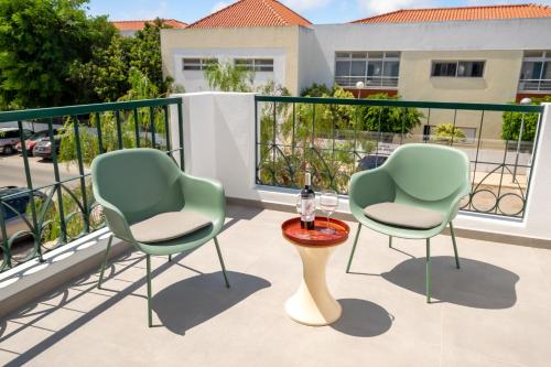 a patio with two chairs and a table on a balcony at Mae Joana pool&beach Faro villa in FAO