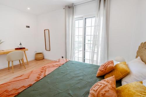 a bedroom with a bed and a desk and a window at Mae Joana pool&beach Faro villa in FAO