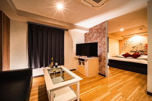 a hotel room with a bed and a television at Hotel M in Oyodo