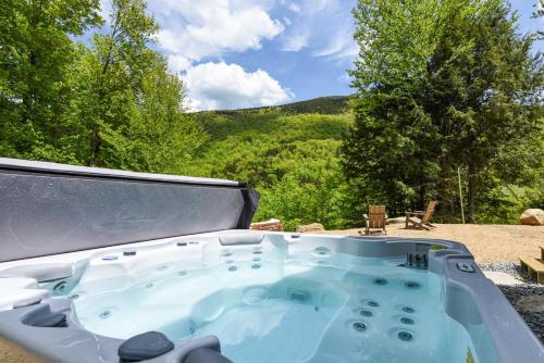 a hot tub with a view of a mountain at Lux Chalet 4 Bd Fireplace HotTub AC Pet Friendly in Killington