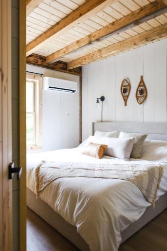 a bedroom with a large white bed with a wooden ceiling at Lux Chalet 4 Bd Fireplace HotTub AC Pet Friendly in Killington