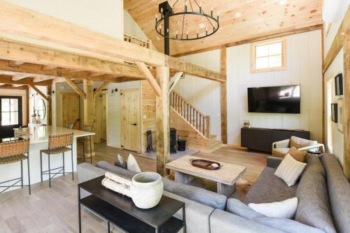 a living room with a couch and a table at Lux Chalet 4 Bd Fireplace HotTub AC Pet Friendly in Killington