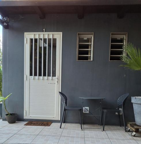 a white door with two chairs and a table at Le Bivouac du Maido studio 1 in Le Guillaume