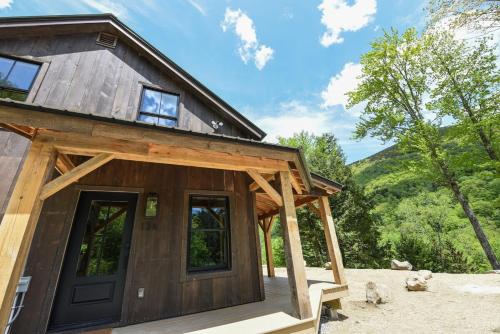 a log cabin with a large door and windows at Lux Chalet 4 Bd Fireplace HotTub AC Pet Friendly in Killington