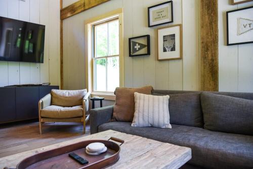a living room with a couch and a table at Lux Chalet 4 Bd Fireplace HotTub AC Pet Friendly in Killington