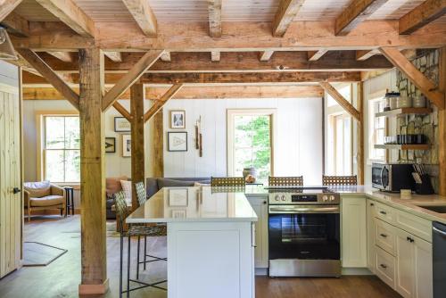 a kitchen with wooden ceilings and a kitchen island at Lux Chalet 4 Bd Fireplace HotTub AC Pet Friendly in Killington
