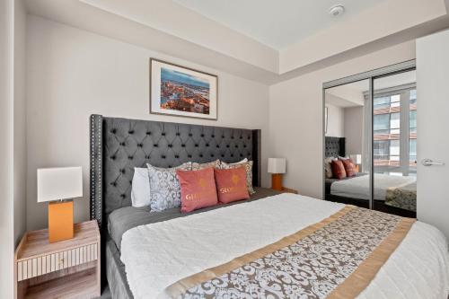 a bedroom with a large bed and a mirror at Bright 1BD & Den in Downtown Toronto in Toronto