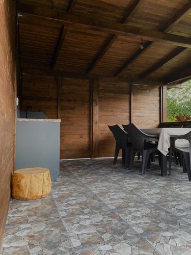 a patio with a table and chairs and a stone floor at Bungalouri Olanesti in Băile Olăneşti