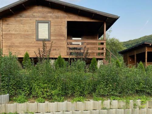 a log cabin with a window and a fence at Bungalouri Olanesti in Băile Olăneşti