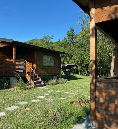 a log cabin with a staircase leading to a yard at Bungalouri Olanesti in Băile Olăneşti