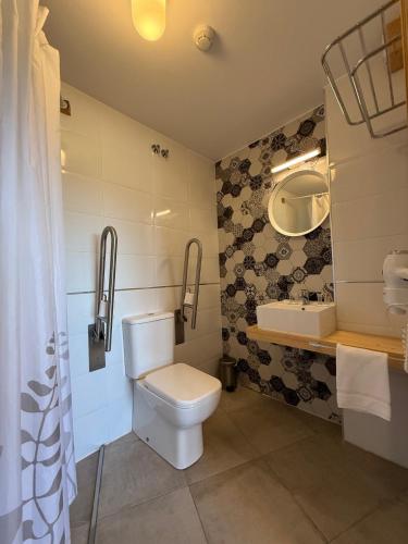 a bathroom with a toilet and a sink at Pension Restaurante Casa Camiño in Palas de Rei 