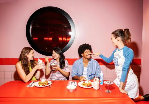a group of people sitting at a table eating food at AMISTAT City Hostel Barcelona in Barcelona