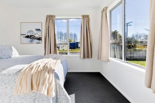 ein Schlafzimmer mit einem Bett und einem großen Fenster in der Unterkunft Large Family Lakehouse in Mangakino