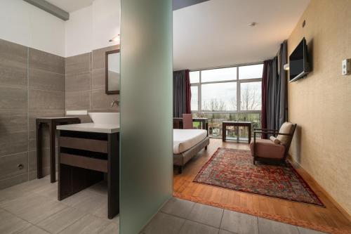 a bathroom with a bed and a sink in a room at Hotel Antares Sport Beauty & Wellness in Villafranca di Verona