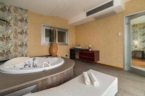 a bathroom with a tub and a sink at Hotel Antares Sport Beauty & Wellness in Villafranca di Verona
