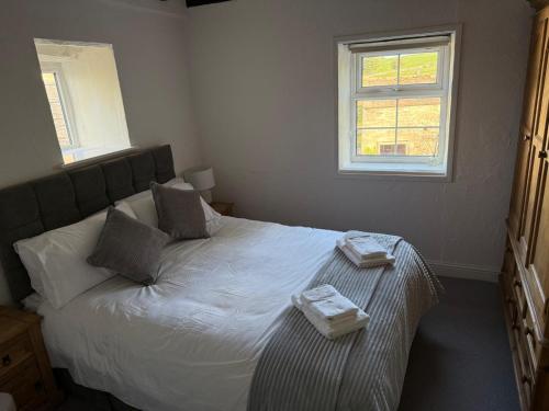 a bedroom with a bed with two towels on it at Swallow Cottage Middleham in Middleham