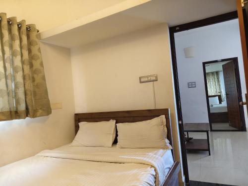 a bed in a room with a window and a mirror at Le Poshe Luxury - TIE Hotels & Resorts in Puducherry