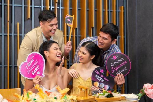 a group of people standing around a table with a cake at Astoria Plaza in Manila
