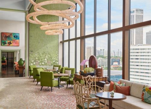 a lobby with tables and chairs and a chandelier at Mandarin Oriental, Singapore in Singapore
